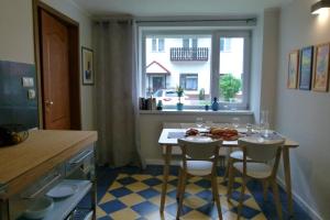 a kitchen with a table and chairs and a window at Apartamenty BB nad Kryniczanką in Krynica Zdrój