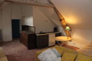 a living room with a couch and a table at A la Ferme de la Joie - Chambres d'Hôtes in Chevannes