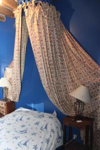 a bedroom with blue walls and a bed with curtains at A la Ferme de la Joie - Chambres d'Hôtes in Chevannes +18 photos