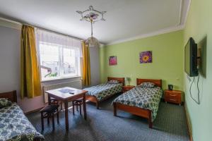 a hotel room with two beds and a table at Regina Guest House in Kaunas