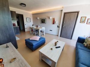 un soggiorno con divano blu e tavolo di George's Apartment a Città di Lefkada