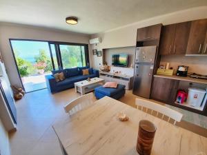 una cucina e un soggiorno con tavolo e divano di George's Apartment a Città di Lefkada