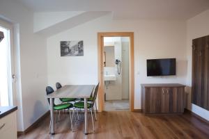 a dining room with a table and chairs and a television at Haller Hof in Tirolo