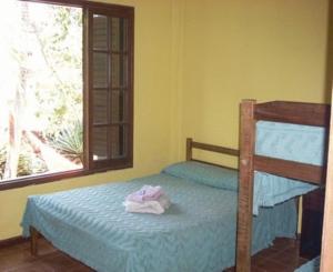 ein Schlafzimmer mit einem Etagenbett und einem Fenster in der Unterkunft El Guembe Hostel House in Puerto Iguazú