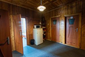 a kitchen with wooden walls and a refrigerator and two doors at Regina House in Kaunas