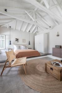 a bedroom with a bed and a chair and a table at SKIA-Cosy Living in Skiathos