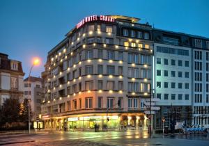a lit up building on a city street at night at Grand Hotel Cravat in Luxembourg