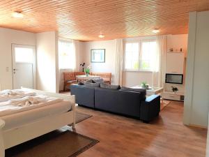 ein Wohnzimmer mit einem Sofa und einem TV in der Unterkunft Ferienbungalow Haus am Teich in Boltenhagen