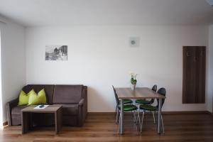 a living room with a couch and a table and chairs at Haller Hof in Tirolo