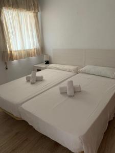 a large white bed with two white pillows on it at Service Apart Lazaro- Apartamentos Aguamarina 14 in Calpe