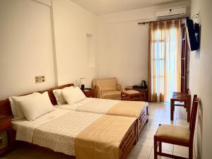 a hotel room with a bed and a chair at Asteri Hotel in Livadi