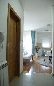 Zimmer mit einer Tür, die zu einem Schlafzimmer führt in der Unterkunft Angellina Apartmani in Sremska Mitrovica