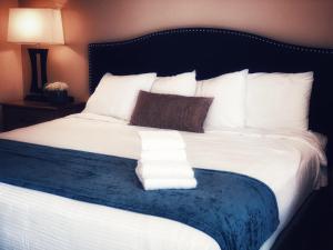een groot bed met witte lakens en kussens erop bij Bay Lodging Resort in Put-in-Bay
