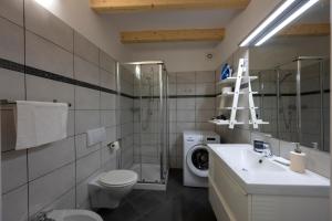y baño con lavamanos y lavadora. en Appartamenti Rivantica, en Riva del Garda