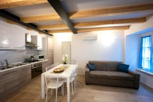 Una cocina y una sala de estar con una mesa y un sofá. en Appartamenti Rivantica, en Riva del Garda 22 fotos más