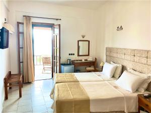 a hotel room with a bed and a desk and a window at Asteri Hotel in Livadion