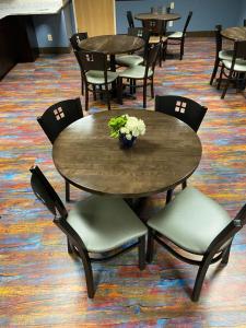 ein Tisch und Stühle mit einer Blumenvase drauf in der Unterkunft Bay Lodging Resort in Put-in-Bay