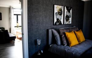 a living room with a blue couch with yellow pillows at A Bascule Bed and Breakfast Maastricht in Riemst