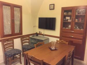 comedor con mesa, sillas y TV en casa MARINO, en Caltabellotta