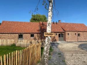 a sign on a tree in front of a house at De Kasseihoeve in Kalken