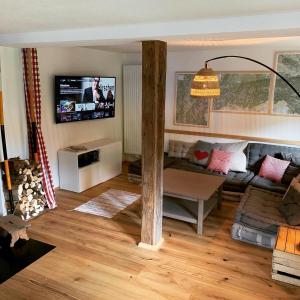 a living room with a couch and a tv at Villgratenhaus in Außervillgraten