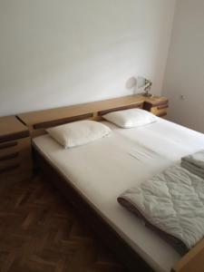 PretrešnjaDomaćinstvo Trifunović的房间里有一张床，上面有两个枕头