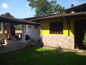een geel en wit huis met een tuin bij Rios Cristalinos em Guapiaçu in Cachoeiras de Macacu