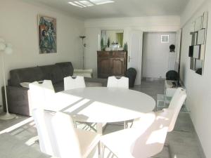uma sala de estar com uma mesa branca e cadeiras brancas em Fettolina Palm Beach, Location Cannes front de mer et plage em Cannes
