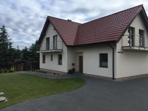 a white house with a red roof at Sielska Chatka in Sarbinowo