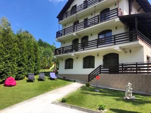 a large building with chairs in the yard at Vila Aldor in Bran