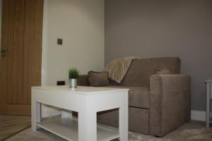 a living room with a couch and a white table at Frinton Escapes in Frinton-on-Sea