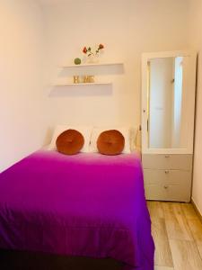 - une chambre avec un lit violet et 2 oreillers en bois dans l'établissement Cómodo apartamento en el corazón dé Tenerife, à La Laguna