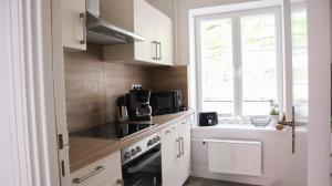uma cozinha com armários brancos e uma janela em Kapitainskoje direkt am Hafen Flensburgs em Flensburg