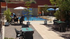 uma piscina com mesa e cadeiras e um parque infantil em Hôtel Ajil Cascades D'ouzoud em Ouzoud