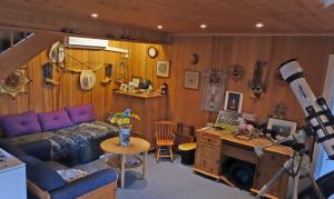 a living room with a couch and a table with a telescope at Risør Bed & Breakfast, Randvik Strand in Risør