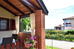 a patio with a window and some chairs and flowers at Apartment Samanta in Novigrad Istria