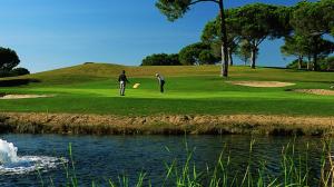 two men playing golf on a golf course next to a river at Tenis Golf Mar by OCvillas in Quarteira
