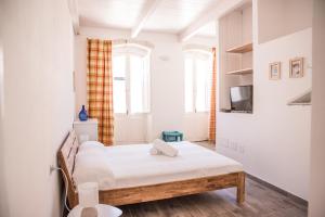 Habitación pequeña con 2 camas y TV. en B&B LE TRE CHIOCCIOLE, en SantʼAntìoco