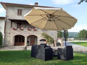een paraplu en stoelen voor een gebouw bij La Fiora in Sansepolcro