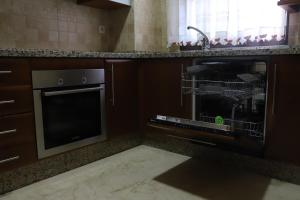a kitchen with a dishwasher and a sink and a microwave at Duplex Santa Teresa in Córdoba