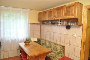 a kitchen with a wooden table in a room at Casa Verde in Râu de Mori