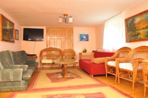 a living room with wicker chairs and a red couch at Casa Verde in Râu de Mori