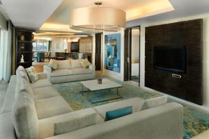 a living room with a couch and a tv at Millennium Al Rawdah Hotel in Abu Dhabi