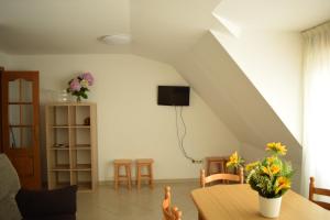 a living room with a table and chairs and a staircase at Apartamentos O Grove in O Grove