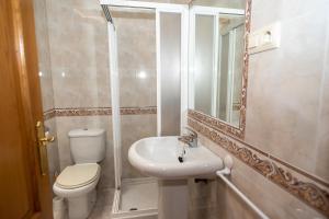 a bathroom with a toilet and a sink and a shower at Apartamentos O Grove in O Grove +65 photos