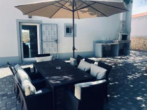 a table and chairs with an umbrella on a patio at Holiday Home Ivan in Peroj