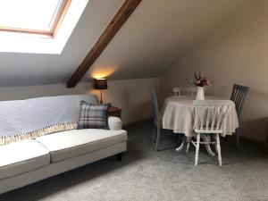 a attic room with a bed and a table and chairs at Harepath Farm Cottages 2 in Exeter