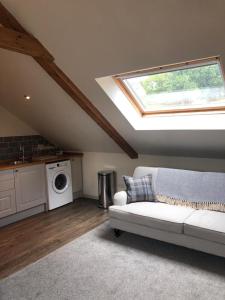a living room with a white couch and a window at Harepath Farm Cottages 2 in Exeter