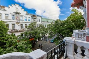 einen Balkon mit Blick auf eine Straße mit Gebäuden in der Unterkunft Apartamentos in Odessa