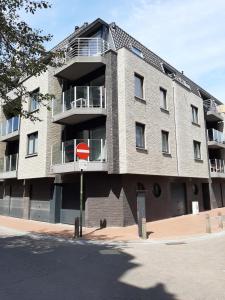 un edificio con una señal de parada roja delante de él en Vakantieappartement Belle Epoque Blankenberge en Blankenberge